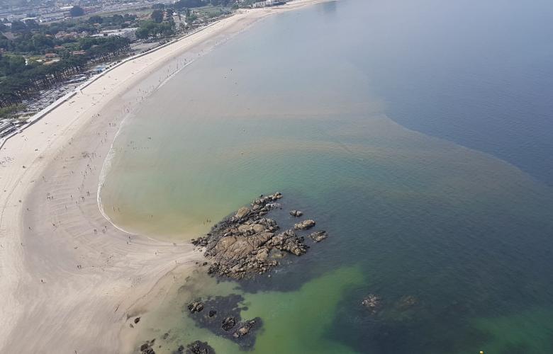 Costa da praia de Samil coloreada por mareas vermellas.